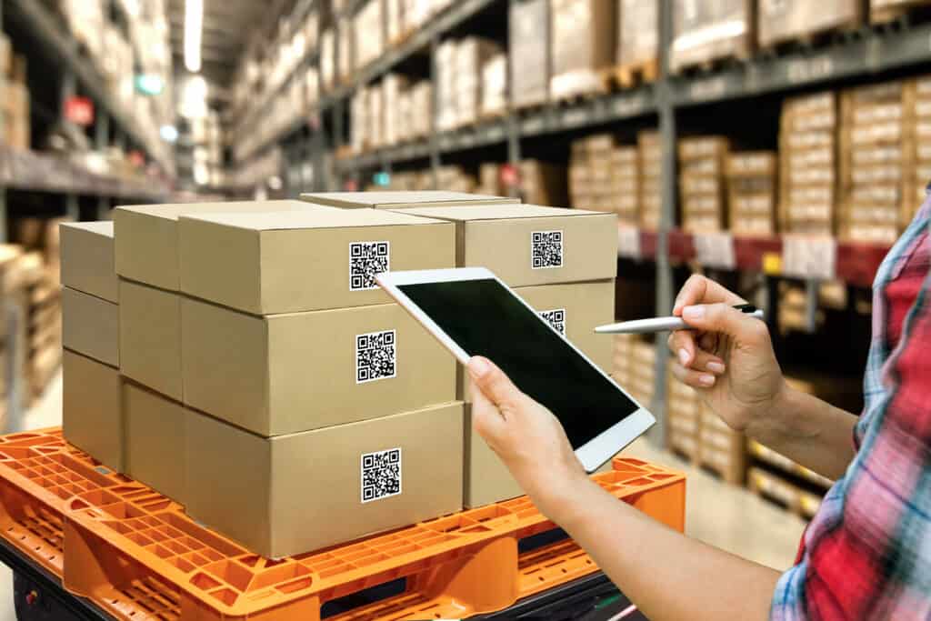 Industrial 4.0 , Augmented reality and smart logistic concept. Hand holding tablet with AR application for check order pick time around the world and supply chain in smart factory background. Using an order management system.