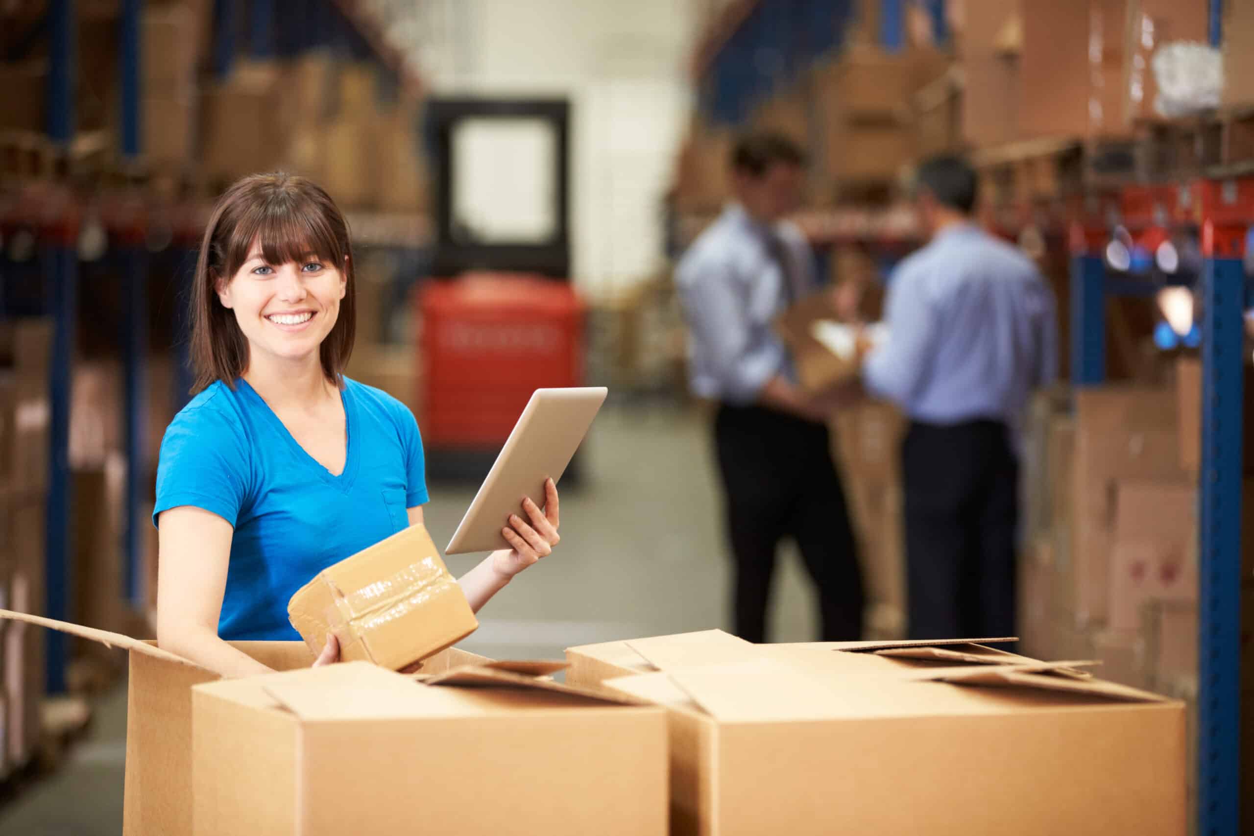Worker In Warehouse Checking Boxes Using Digital Tablet and an Order Management System